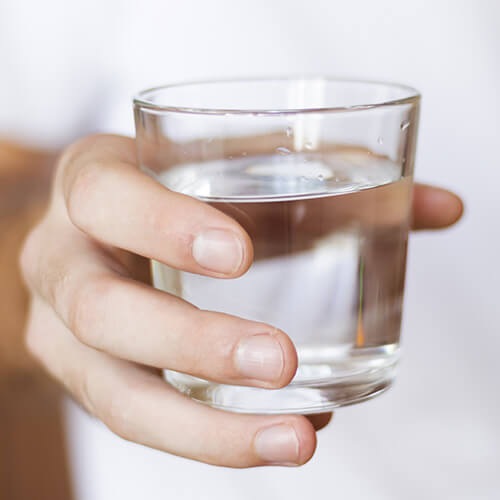 hand holding glass of drinking water