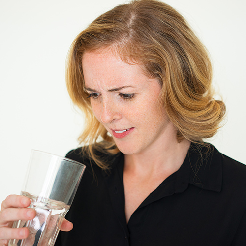 woman looking into water wondering if there's lead in it & how to remove it