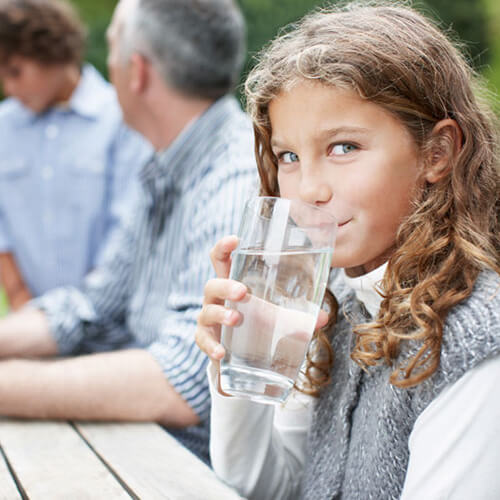 girl drinking glass of potentially chlorinated water