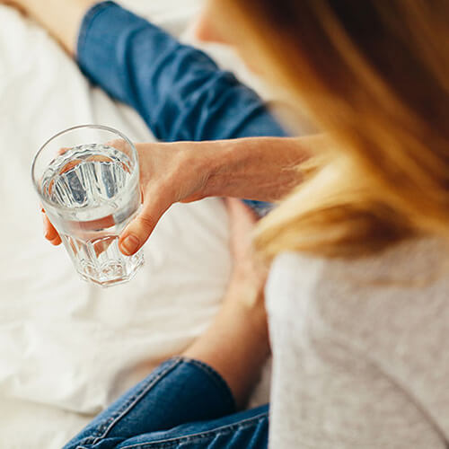 woman holding a glass of soft water or hard water