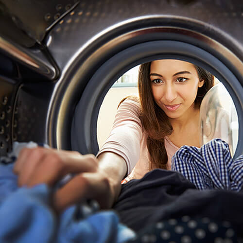 woman removing softened clothes from dryer