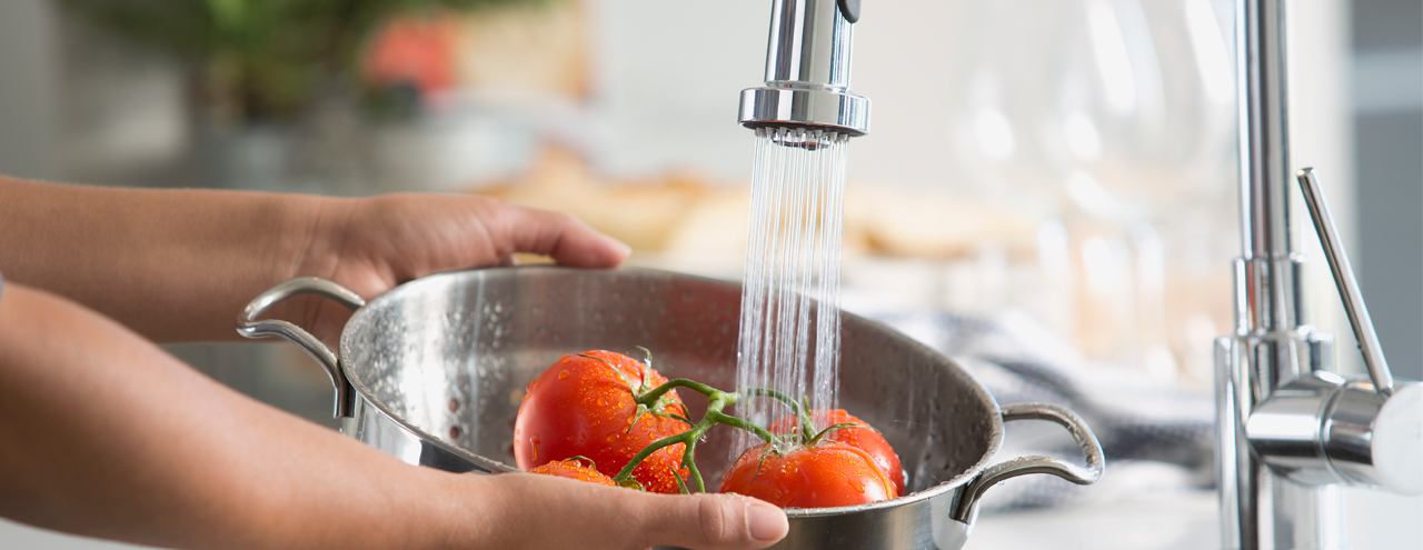 person washing off tomatoes