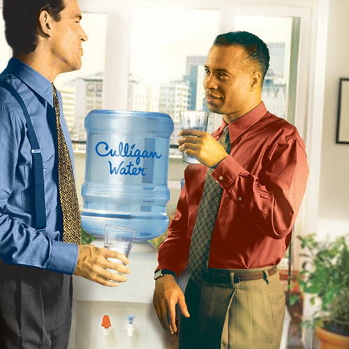 Office workers drinking from Culligan water dispenser