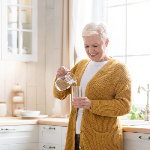 woman drinking water in kitchen
