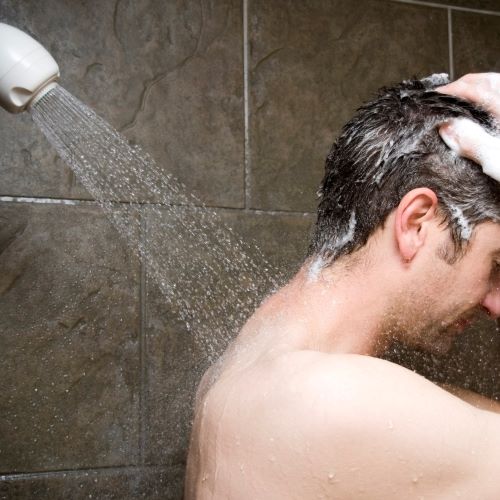 man using shower head filter
