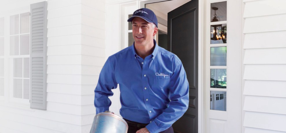 Culligan delivery man delivering portable exchange soft water tank.
