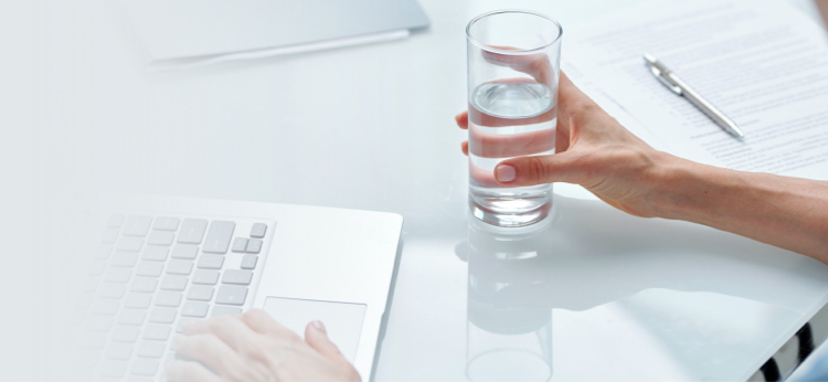 employee drinking glass from bottless water cooler
