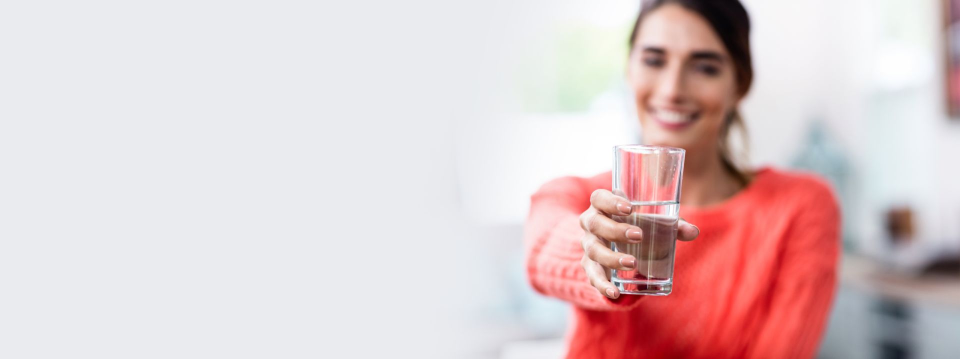 Woman holding glass of clean cold dispensed water