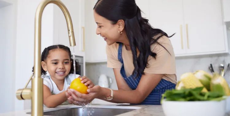 mother and daughter washing fruit with filtered well water