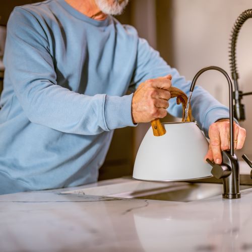Man filling kettle to boil water